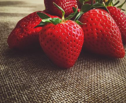 Organic strawberries on rustic linen background, fruit farming and agriculture