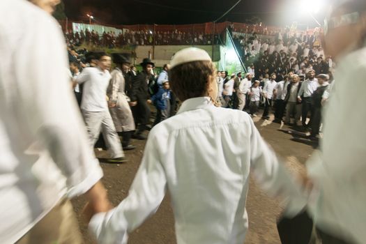 MERON, ISRAEL - MAY 18, 2014: Orthodox Jews dance at the annual hillulah of Rabbi Shimon Bar Yochai, in Meron, on Lag BaOmer Holiday. This is an annual celebration at the tomb of Rabbi Shimon