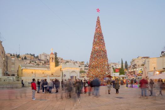 NAZARETH, ISRAEL - DECEMBER 20, 2016: Christmas scene of Mary Well square, with the Greek Orthodox Church of the Annunciation, a Christmas tree, locals and tourists, in Nazareth, Israel