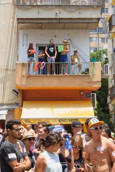 TEL-AVIV - JUNE 13, 2014: Spectator refresh the pride parade participants with cold water. The annual parade in the streets of Tel-Aviv, Israel is held on a hot June day.