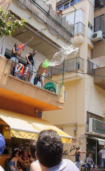 TEL-AVIV - JUNE 13, 2014: Spectator refresh the pride parade participants with cold water. The annual parade in the streets of Tel-Aviv, Israel is held on a hot June day.