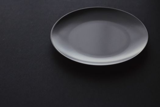 Empty plates on black background, premium dishware for holiday dinner, minimalistic design and diet concept