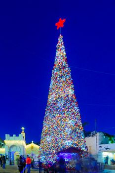 NAZARETH, ISRAEL - DECEMBER 20, 2016: Christmas scene of Mary Well square, with the Greek Orthodox Church of the Annunciation, a Christmas tree, locals and tourists, in Nazareth, Israel