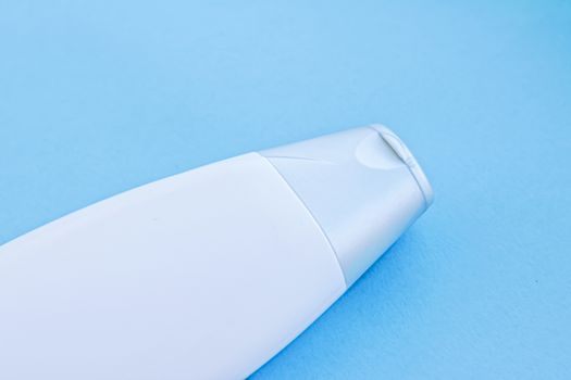 Blank label cosmetic container bottle as product mockup on blue background, hygiene and healthcare