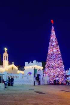 NAZARETH, ISRAEL - DECEMBER 20, 2016: Christmas scene of Mary Well square, with the Greek Orthodox Church of the Annunciation, a Christmas tree, locals and tourists, in Nazareth, Israel