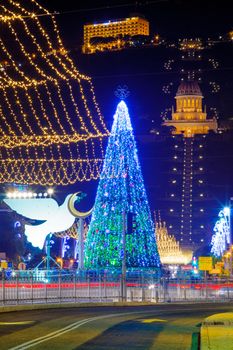 HAIFA, ISRAEL - DECEMBER 28, 2016: The German Colony, decorated for the holidays, with a Christmas tree, Hanukkah Menorah and the Bahai gardens and shrine in the background, in Haifa, Israel