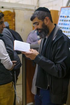 NETIVOT, ISRAEL - JANUARY 30, 2017: Jewish men pray at the Rabbi Israel Abuhatzeira (Baba Sali) tomb, as part of the annual hillula of his memory. In Netivot, Israel