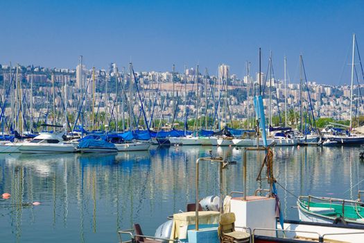 HAIFA, ISRAEL - JULY 31, 2015: Yacht at the Shavit Anchorage, part of the Kishon Port, and the city of Haifa in the background. Haifa, Israel