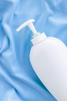 Blank label bottle of antibacterial liquid soap and hand sanitizer mockup on blue silk, hygiene product and health care, flatlay