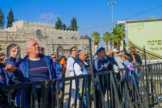 NETIVOT, ISRAEL - JAN 30, 2017: Jewish men practice a traditional tossing of candles into a furnace, at Rabbi Israel Abuhatzeira (Baba Sali) tomb, at the annual hillula of his memory. Netivot, Israel