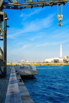 TEL-AVIV, ISRAEL - JANUARY 12, 2017: Scene with a restored crane, a carrousel, a commercial area, the Reading power station chimney, and visitors, in Tel-Aviv Port, Tel-Aviv, Israel