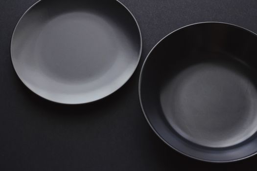 Empty plates on black background, premium dishware for holiday dinner, minimalistic design and diet concept