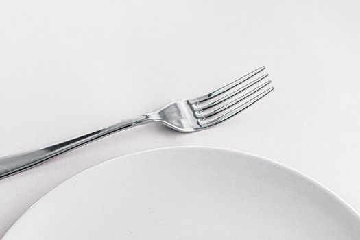 Empty plate and cutlery as mockup set on white background, top tableware for chef table decor and menu branding design