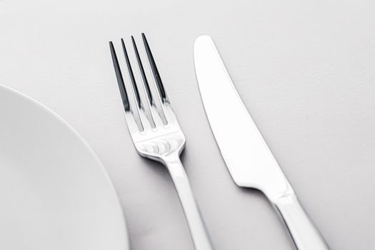 Empty plate and cutlery as mockup set on white background, top tableware for chef table decor and menu branding design