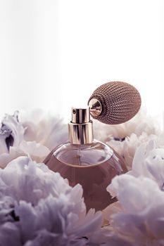 Luxe fragrance bottle as vintage perfume product on violet background and peony flowers, parfum ad and beauty branding design