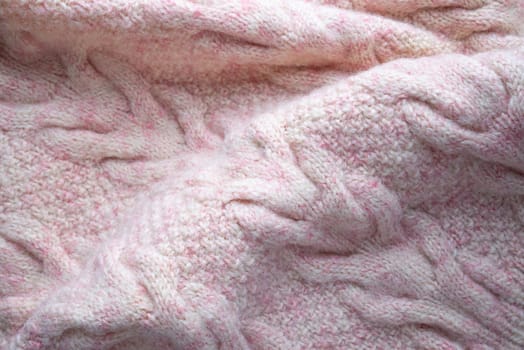 Soft folds of a warm pink knitted woolen pullover to be used as background