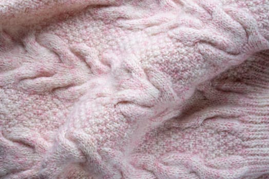 Soft folds of a warm pink knitted woolen pullover to be used as background