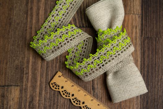 knitted green openwork linen ribbon tapes in rural style of rustics cotton eco natural on wood ground