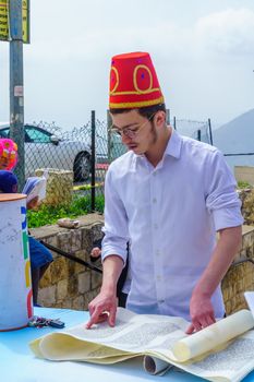 Safed, Israel - March 10, 2020: Jewish men and women in costumes read the megillah (Scroll of Esther), it is a tradition of Purim (Jewish Holiday). In the old city of Safed (Tzfat), Israel