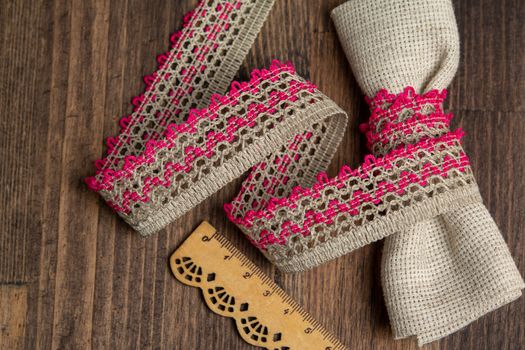 knitted pink openwork linen ribbon tapes in rural style of rustics cotton eco natural on wood ground