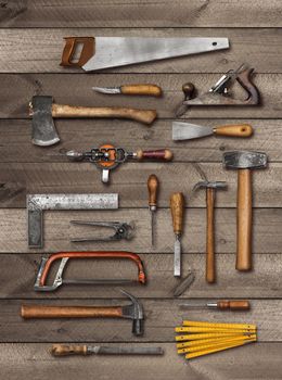 Old carpenter DIY hand tools on weathered wooden plank background, soft drop shadow
