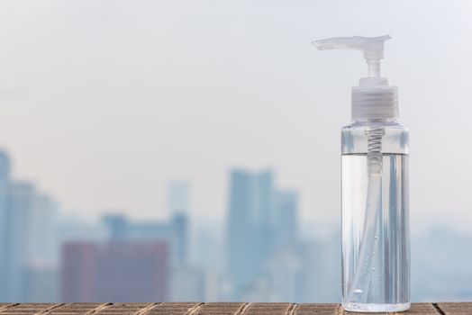Hand sanitizer container against out of focus city skyline aerial view