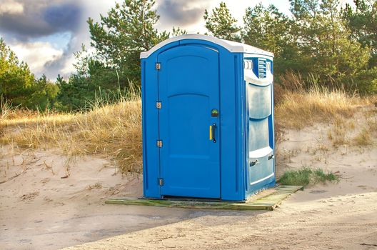 Toilet house on a construction site. Portable bio-toilet cabin. Bio toilet on the beach for workers or tourist.