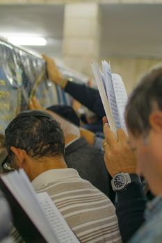 NETIVOT, ISRAEL - JAN 13, 2016: Jewish men pray at the Rabbi Israel Abuhaseira (Baba Sali) tomb, while reaching the mark with their hands, as part of the annual hillula of his memory. Netivot, Israel