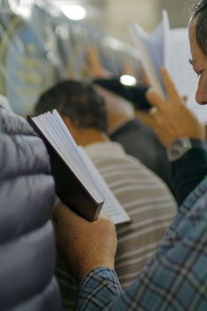 NETIVOT, ISRAEL - JAN 13, 2016: Jewish men pray at the Rabbi Israel Abuhaseira (Baba Sali) tomb, while reaching the mark with their hands, as part of the annual hillula of his memory. Netivot, Israel