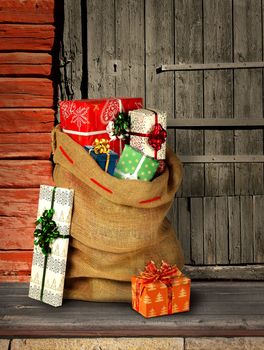 Santas present sack with gift boxes on rough wooden log cabin entrance