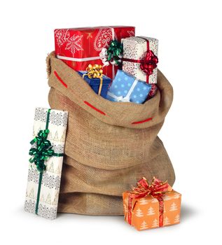 Santas Christmas present burlap sack full of beautiful present boxes isolated on white