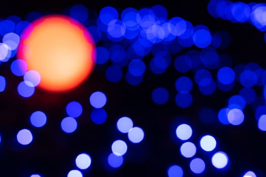 Defocused abstract blue christmas background with orange light