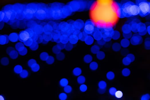Defocused abstract blue christmas background with orange light
