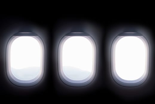 three airplane windows open white window shutter wide
out to view of mountain hilltop during travel by air