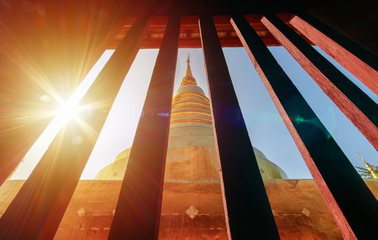 golden pagoda view from vintage window at Wat Phra Singh in Chiang Mai, Thailand with light flare in the morning. travel destination landmark