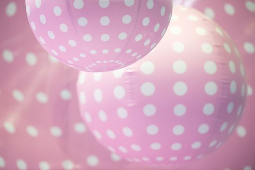 Pink plastic balls with white dots background