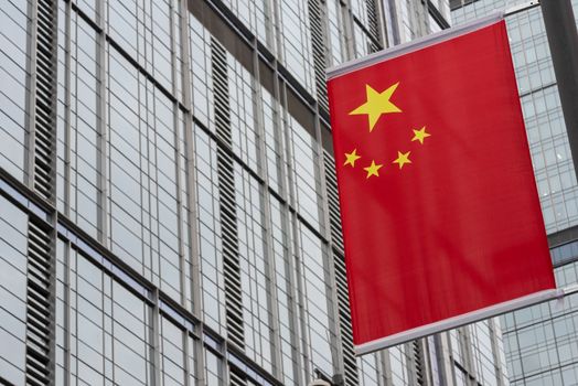 chinese flag close-up view against skyscraper facade