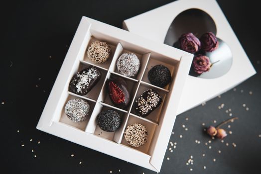 handmade sugar free and gluten free fruit and chocolate candies in a white box and black background