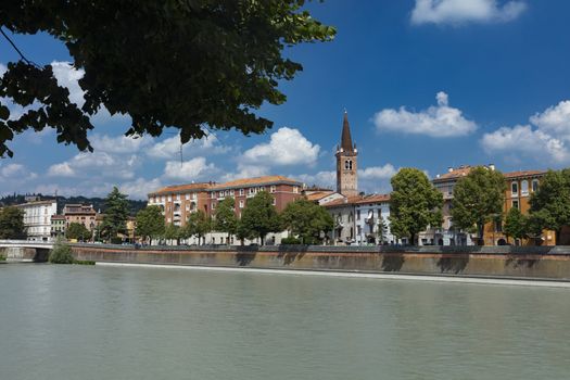 Verona, Italy, Europe, August 2019, view of the River Adige and the tower of the Chiesa Parrocchiale di Santa Maria in Organo