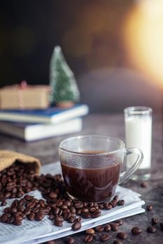 a cup of hot espresso coffee drink with smoke and roasted coffee beans on the table in the morning. vertical image, cropped shot