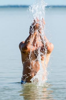 Young man in the lake at summer with drops