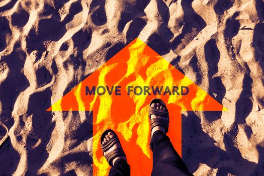 typography motivation. move forward on orange arrow on sand and man's feet