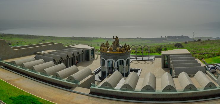 KORAZIM, ISR - JAN 22, 2016: Panoramic view of the Sea of Galilee, with dormitories, Jesus and the 12 apostles and visitors, in the Domus Galilaeae Monastery, on the Mount of Beatitudes, Israel