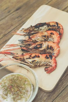 Grilled shrimp (Giant freshwater prawn) grilling with charcoal premium grade display for sale at Thai street food market or restaurant in Bangkok Thailand