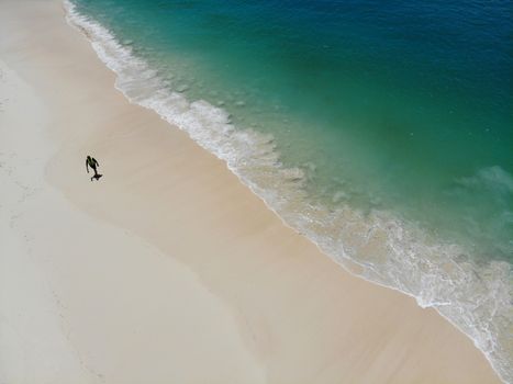 Alone men walk on the beach in summer with sea waves  clear and beautiful color top view by drone