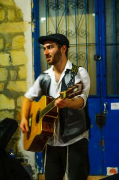 SAFED, ISRAEL - AUGUST 23, 2017: Scene of the Klezmer Festival, with street musician playing, in Safed (Tzfat), Israel. Its the 30th annual traditional Jewish festival in the public streets of Safed