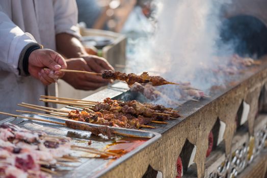 Man cooking skewers on a traditional market in Chengdu, Sichuan province, China