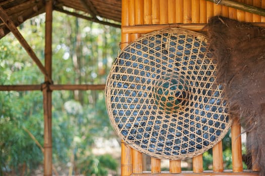 Chinese straw hat hanging on a bamboo wall in the countryside, China
