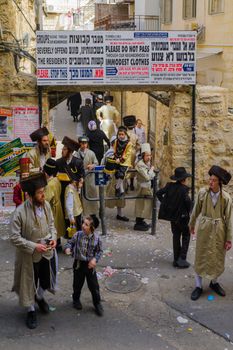 JERUSALEM, ISRAEL - MARCH 25, 2016: Street scene of the Jewish Holyday Purim, with locals, some wearing costumes, in the ultra-orthodox neighborhood Mea Shearim, Jerusalem, Israel