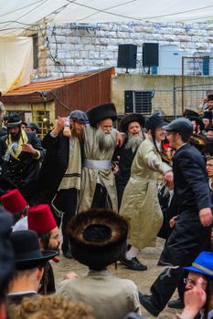 JERUSALEM, ISRAEL - MARCH 25, 2016: Jewish men attend and dance, as part of a celebration of the Jewish Holyday Purim, in the ultra-orthodox neighborhood Mea Shearim, Jerusalem, Israel